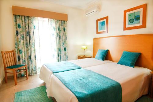 Flamingo Apartments في بورتيماو: غرفة نوم بسرير كبير ونافذة