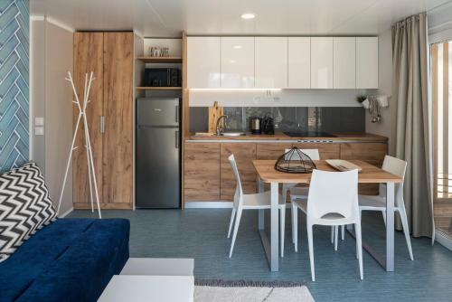 a kitchen and dining room with a table and chairs at Falkensteiner Premium Mobile Homes and Camping Zadar in Zadar