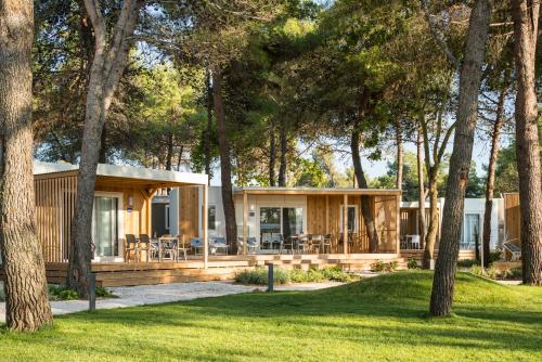 Falkensteiner Premium Mobile Homes and Camping Zadar في زادار: كابينة في الغابة فيها اشجار