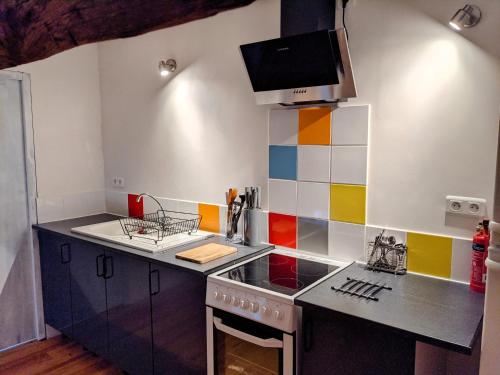 - une cuisine colorée avec une cuisinière et un évier dans l'établissement Chez Elle, à Rancon