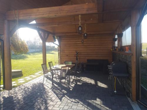 a patio with a table and chairs in a wooden cabin at Biały Jeleń z basenem i jacuzzi in Białka Tatrzanska