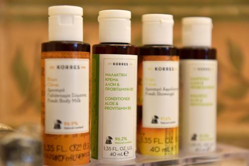 a group of four bottles of hair products on a shelf at Angelica Traditional Boutique Hotel in Hydra