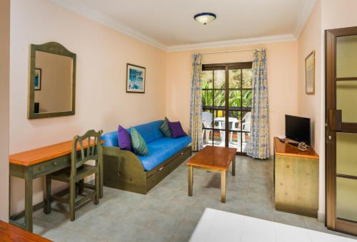 sala de estar con sofá azul y mesa en Residencial el Conde #7, en Valle Gran Rey