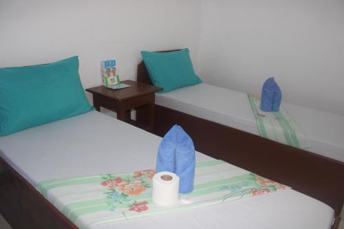 two beds in a room with a toilet paper holder at Love Vega Hometel in El Nido