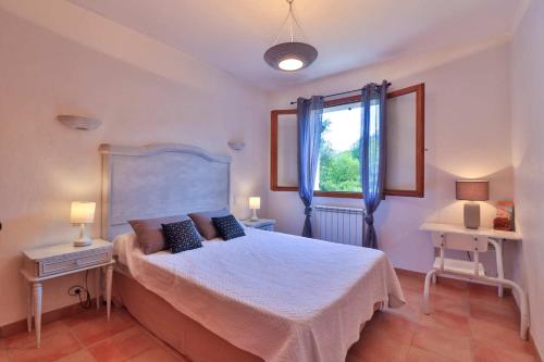 a bedroom with a large bed and a window at Locations-06 la Pascaline in Le Bar-sur-Loup