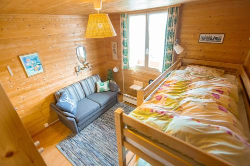 a bedroom with a bed and a couch in a room at Chalet Ruedi - CharmingStay in Flumserberg
