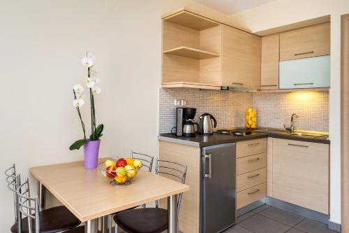 a kitchen with a table with a bowl of fruit on it at Aventura Apartments Potos in Potos