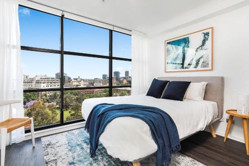 ein Schlafzimmer mit Bett und großen Fenstern in der Unterkunft Surry Hills Modern One Bedroom Apartment -GOUL in Sydney