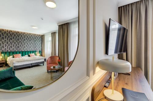 a living room with a large mirror in a hotel room at Hotel Willa Tatrzańska in Krynica Zdrój