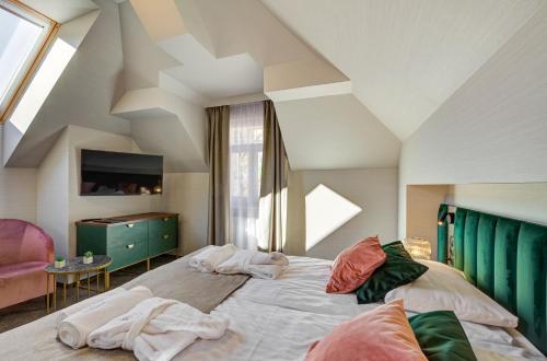 a bedroom with a large bed with towels on it at Hotel Willa Tatrzańska in Krynica Zdrój