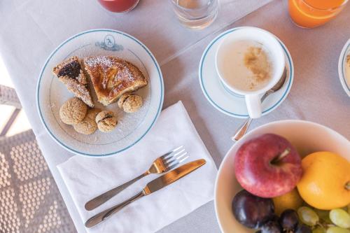 Una mesa con dos tazones de comida y una taza de café. en Olimpionico Hotel, en Castello di Fiemme