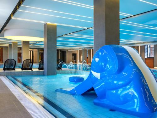 a blue dolphin in a pool in a building at Mercure Krakow Fabryczna City in Krakow