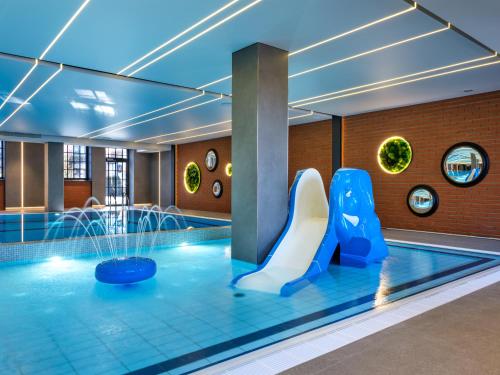 a pool with a slide and a water park at Mercure Krakow Fabryczna City in Kraków