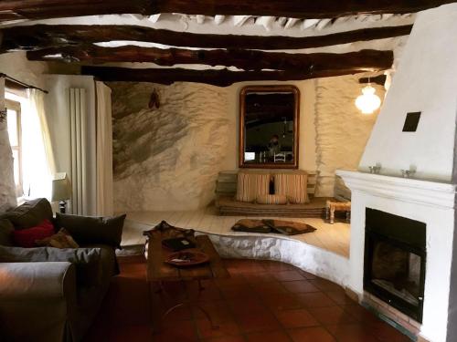a living room with a couch and a fireplace at Cortijo La Viñuela in Atalbéitar