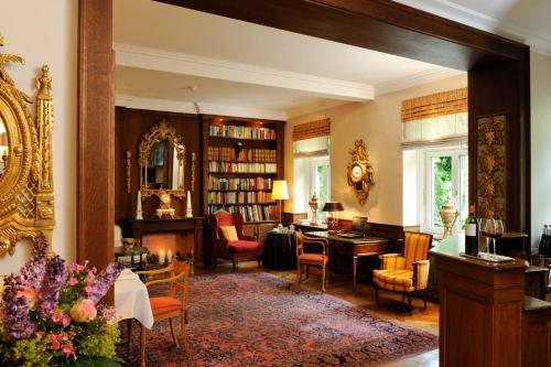 a room with a library with a desk and chairs at Boutique Hotel Splendid in Munich