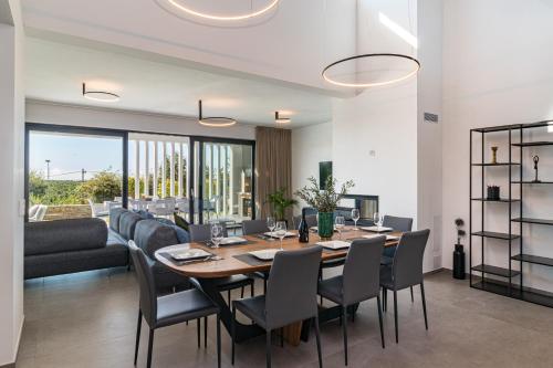 a dining room and living room with a table and chairs at Villa Sabina in Višnjan