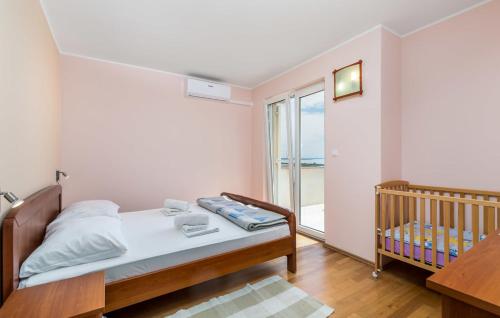 a bedroom with a bed and a crib and a window at Apartment Nadica in Novalja