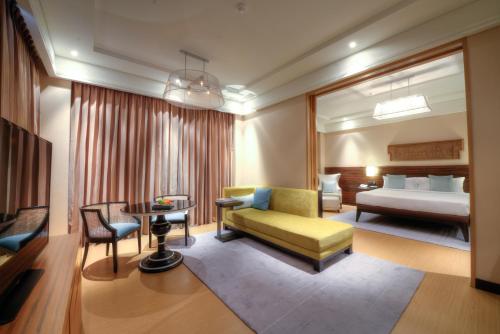 Una habitación de hotel con una cama y una sala de estar. en The Raintree, St. Mary’s Road, en Chennai