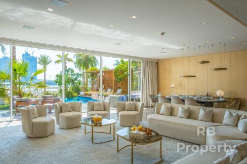 FIVE Palm Beach Villa - Three Floors, Private Pool, Jacuzzi في دبي: غرفة معيشة مع أريكة وكراسي وطاولة