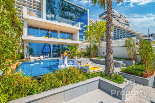FIVE Palm Beach Villa - Three Floors, Private Pool, Jacuzzi في دبي: صوره لمبنى به مسبح