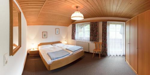 a bedroom with a large bed with a wooden ceiling at Apartment Ilishof in Schruns