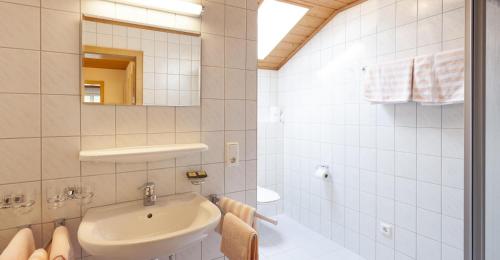 a white bathroom with a sink and a mirror at Apartment Ilishof in Schruns-Tschagguns