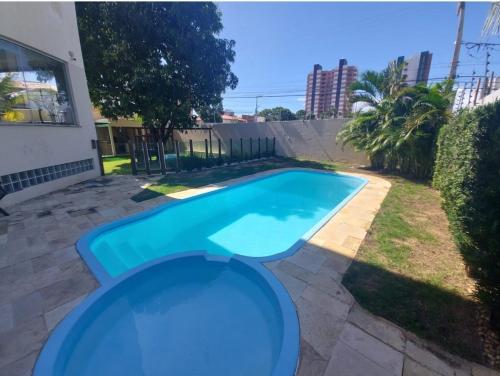 een klein blauw zwembad in een tuin bij Lindo apartamento na Atalaia pertinho da praia in Aracaju