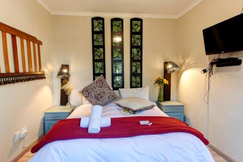 a bedroom with a bed with a towel on it at Penguin - Double En-Suite Studio in Cape Town