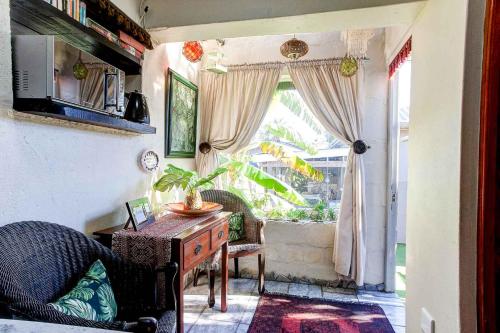 a living room with a table and a window at Penguin - Double En-Suite Studio in Cape Town