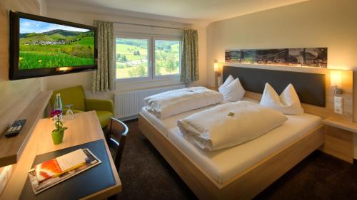 ベルナウ・イム・シュヴァルツヴァルトにあるGasthaus Löwenのベッドとテレビがあるホテルの部屋