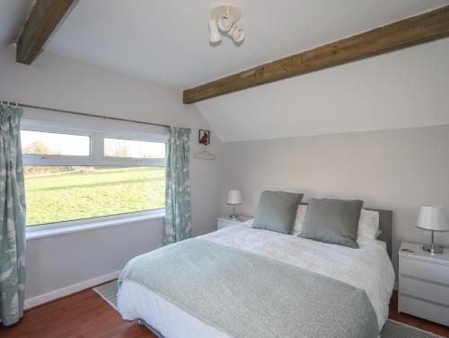 a bedroom with a bed and a large window at Oscar's Pad in Llanfairpwllgwyngyll