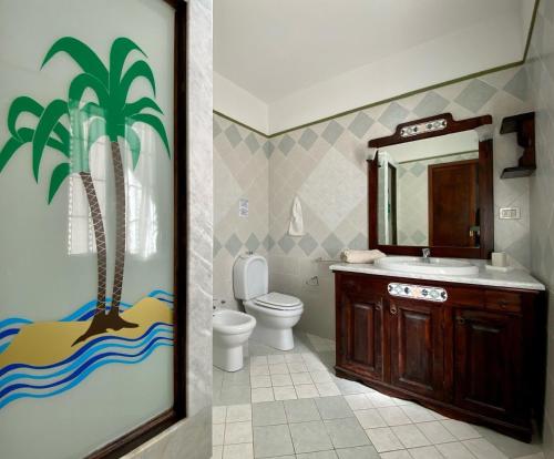 a bathroom with a palm tree painted on the wall at Villa Francesca in Fontane Bianche