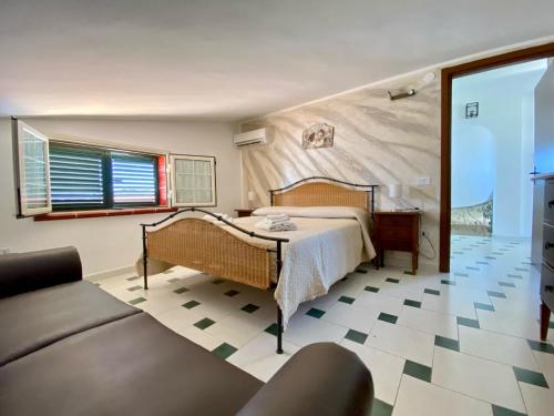 a bedroom with a bed and a couch at Villa Francesca in Fontane Bianche
