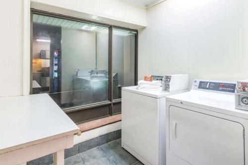 a kitchen with a washing machine and a window at Ramada by Wyndham West Atlantic City in West Atlantic City