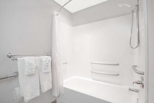 a white bathroom with a bath tub and a sink at Microtel Inn & Suites by Wyndham Gardendale - Birmingham North in Gardendale