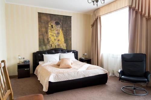 a bedroom with a bed and a chair and a painting at Voyage Hotel Complex in Kazan