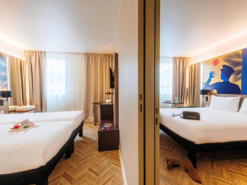a hotel room with two beds and a room with at ibis Styles Nice Aéroport Arenas in Nice