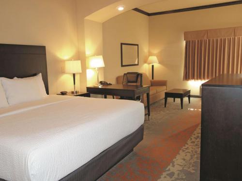 a hotel room with a bed and a desk at La Quinta by Wyndham Eastland in Eastland