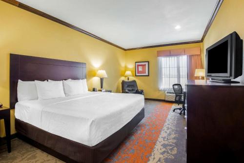 a hotel room with a bed and a flat screen tv at La Quinta by Wyndham Eastland in Eastland