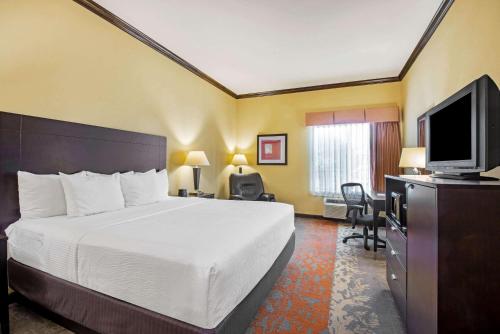 a hotel room with a bed and a flat screen tv at La Quinta by Wyndham Eastland in Eastland