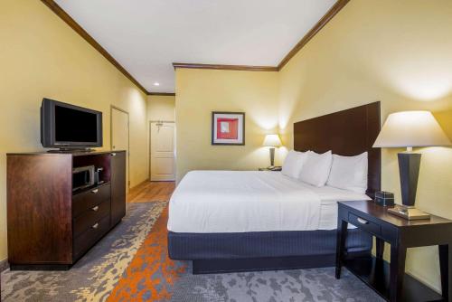 a hotel room with a bed and a flat screen tv at La Quinta by Wyndham Eastland in Eastland