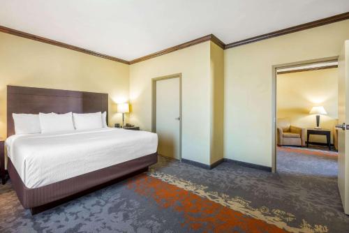 a hotel room with a bed and a door to a bedroom at La Quinta by Wyndham Eastland in Eastland