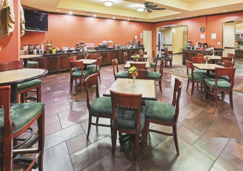 a restaurant with tables and chairs and a bar at La Quinta by Wyndham Eastland in Eastland