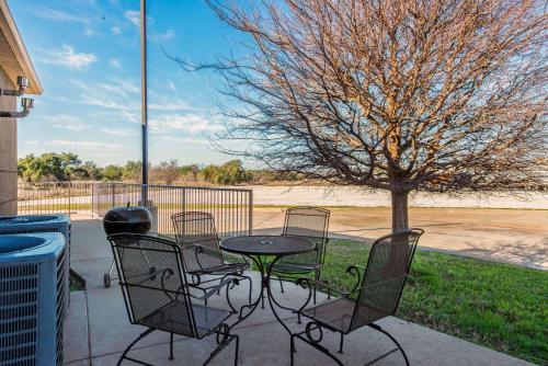 a patio with a table and chairs and a tree at La Quinta by Wyndham Eastland in Eastland