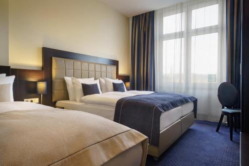 ハンブルクにあるノヴム ホテル コンチネンタル ハンブルグ ハウプトバーンホフのベッド2台と窓が備わるホテルルームです。