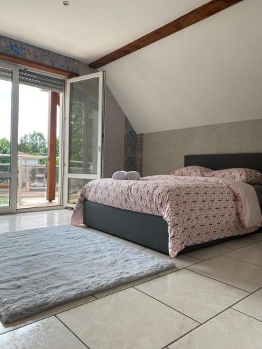 a bedroom with a bed and a large window at Magnifique villa piscine dans un écrin de verdure in Eckbolsheim