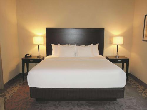 a large bed in a hotel room with two lamps at La Quinta by Wyndham Eastland in Eastland