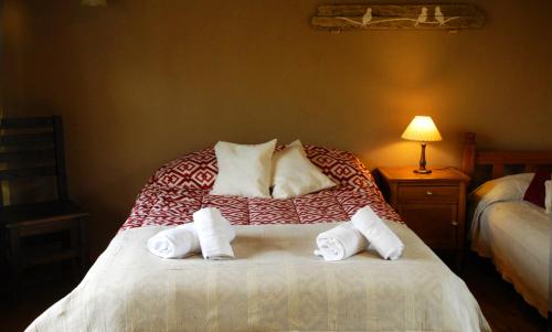 1 dormitorio con 1 cama con toallas en La Chacra del Médano en El Calafate