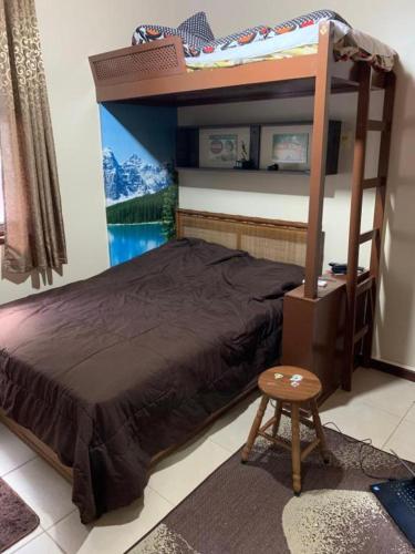 a bedroom with a bunk bed and a stool at LOFT EM PETRÓPOLIS - ITAIPAVA in Petrópolis