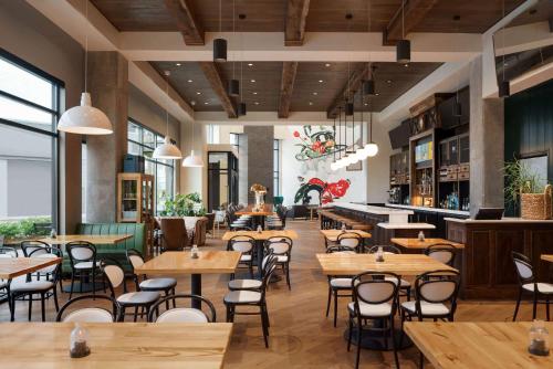 un restaurant avec des tables et des chaises en bois dans l'établissement Origin Lexington, a Wyndham Hotel, à Lexington